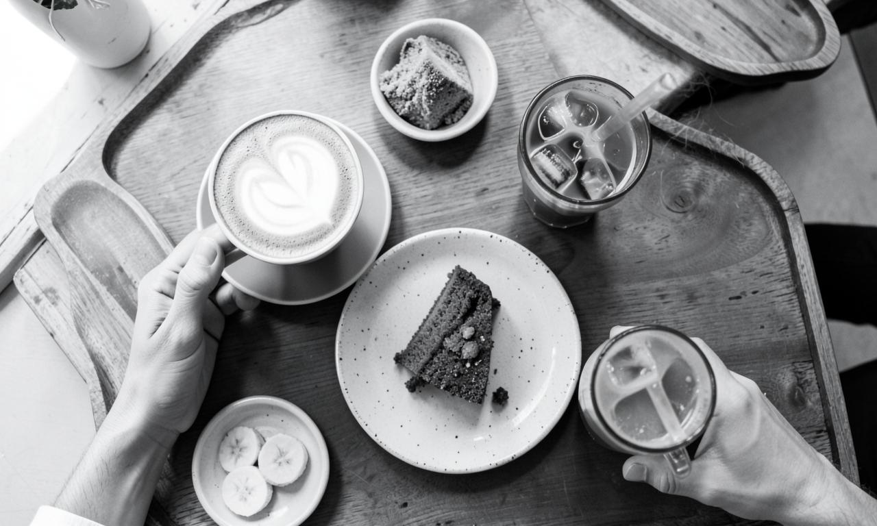 Overhead view of coffee, cake, and iced drinks on a cafe table